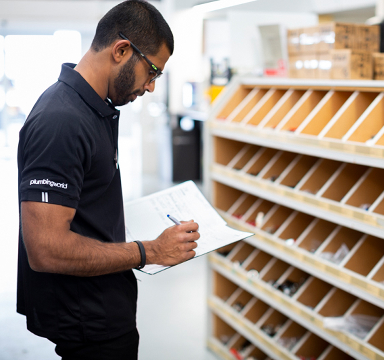 Plumbing World Careers | Trade Staff checking off orders